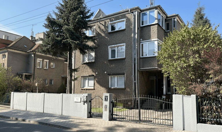 Three-story accommodation building at 117 Grodziska Street, Poznań, with trees.