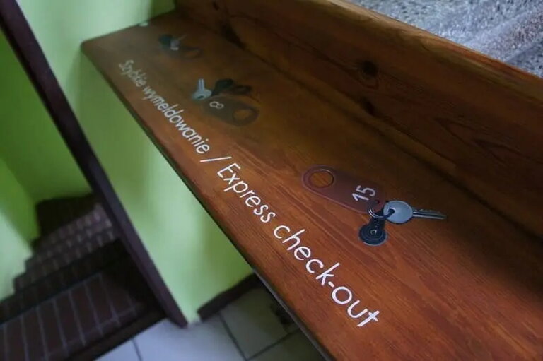 Wooden Express check-out shelf with room keys by the exit