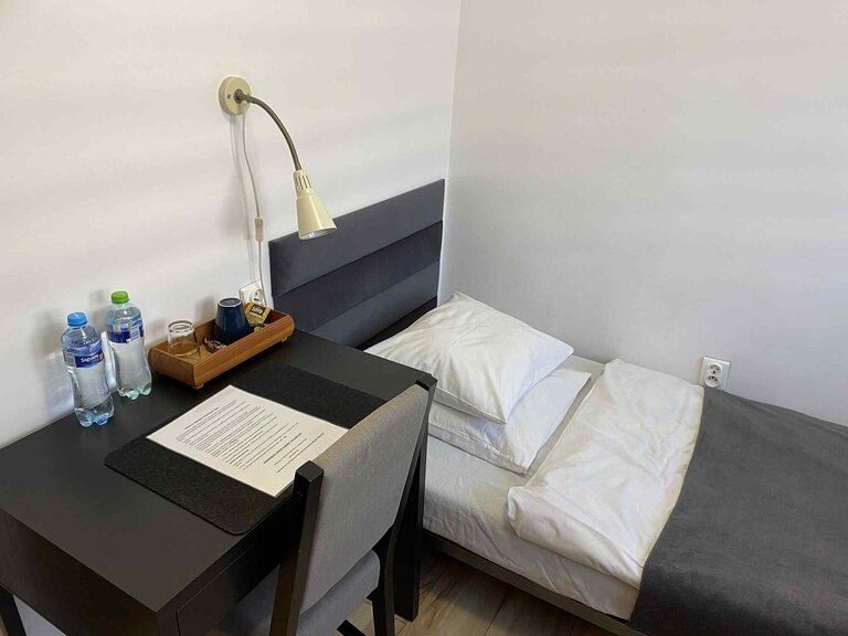 Economy room with single bed, desk lamp and welcome tray with coffee.